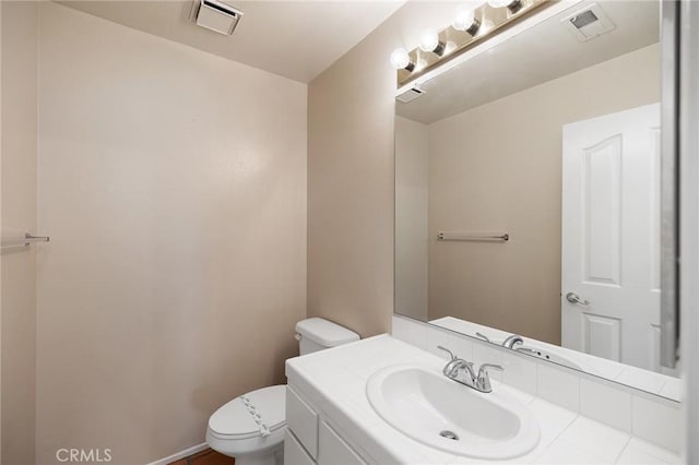 half bath featuring toilet, visible vents, and vanity