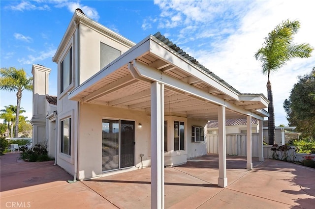 back of property featuring a patio, stucco siding, and fence