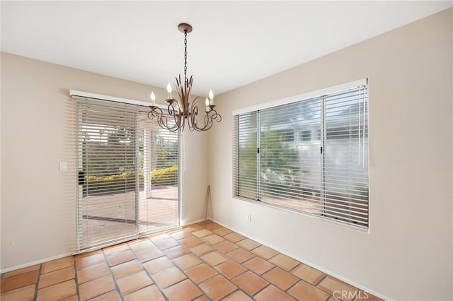 spare room with light tile patterned floors, baseboards, and an inviting chandelier