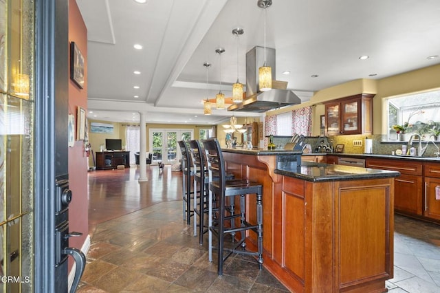 kitchen featuring a sink, island exhaust hood, glass insert cabinets, and recessed lighting
