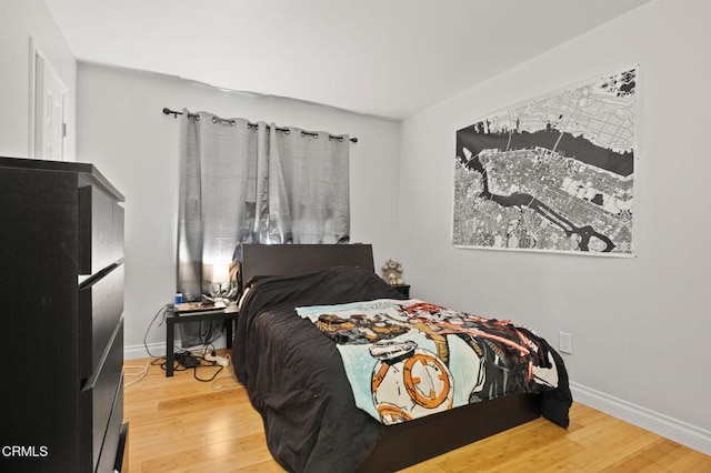 bedroom with wood finished floors and baseboards