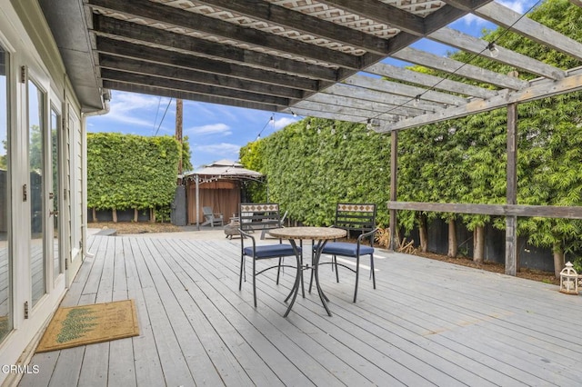 wooden deck with outdoor dining area and a pergola