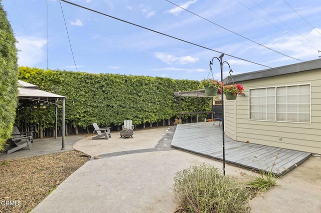 view of patio / terrace featuring an outdoor fire pit, a wooden deck, and a gazebo