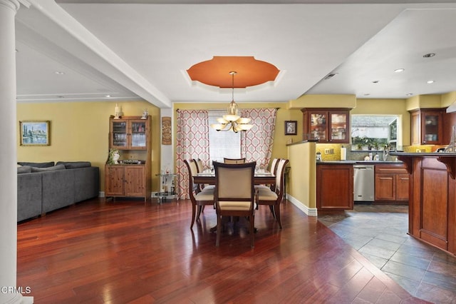dining room featuring baseboards, recessed lighting, dark wood finished floors, a tray ceiling, and a notable chandelier