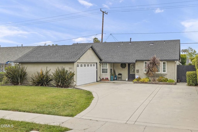 ranch-style house featuring an attached garage, stucco siding, concrete driveway, a front yard, and roof with shingles