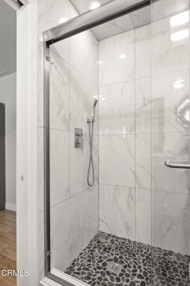 full bathroom with a marble finish shower
