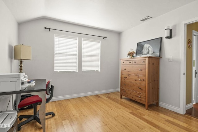 office area featuring baseboards, vaulted ceiling, visible vents, and wood finished floors