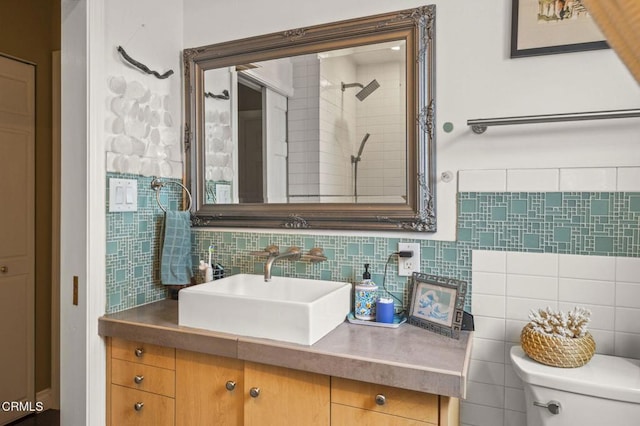 bathroom with vanity, toilet, and decorative backsplash