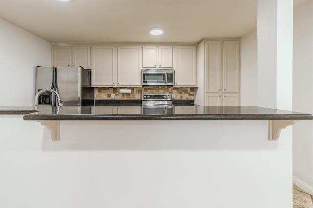 9860 Dale Ave Unit D10, Spring Valley, CA 91977 - kitchen featuring appliances with stainless steel finishes, decorative backsplash, dark stone counters, a kitchen breakfast bar, and recessed lighting