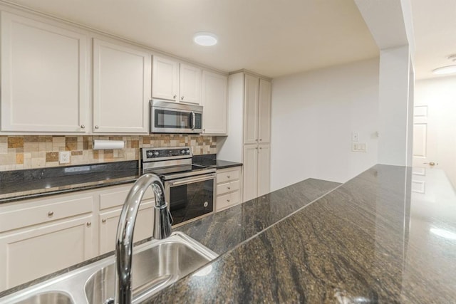9860 Dale Ave Unit D10, Spring Valley, CA 91977 - kitchen featuring appliances with stainless steel finishes, tasteful backsplash, white cabinetry, and dark stone counters