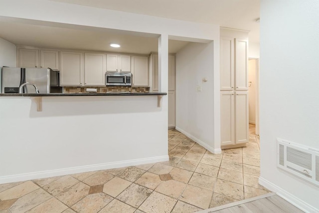 9860 Dale Ave Unit D10, Spring Valley, CA 91977 - kitchen featuring appliances with stainless steel finishes, dark countertops, stone tile flooring, and backsplash