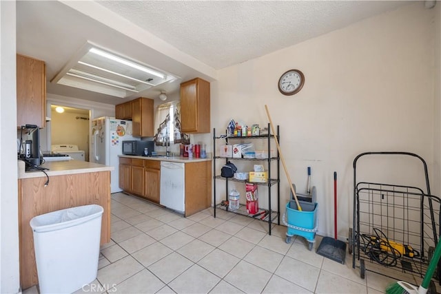 45324 Rodin Ave, Lancaster, CA 93535 - kitchen with washer / clothes dryer, light tile patterned floors, brown cabinetry, white appliances, and light countertops