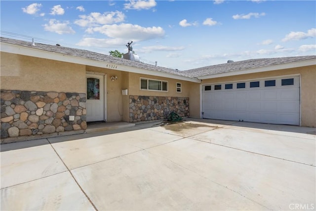 45324 Rodin Ave, Lancaster, CA 93535 - ranch-style home featuring concrete driveway, an attached garage, stucco siding, and stone siding