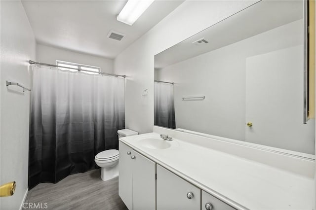 full bathroom featuring vanity, toilet, visible vents, and wood finished floors