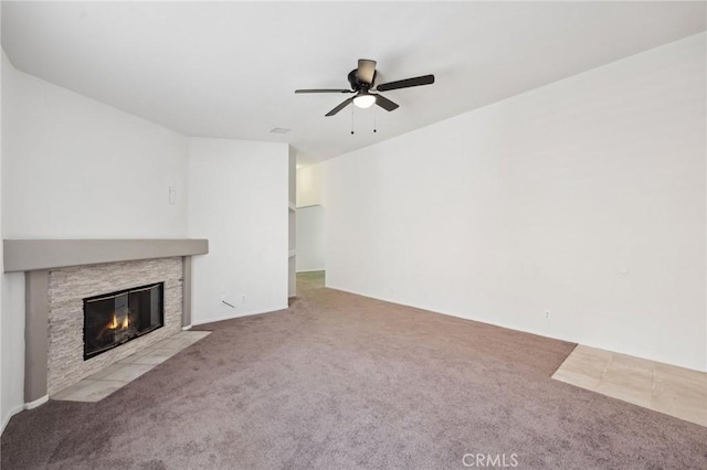 unfurnished living room with a ceiling fan, a fireplace, and carpet