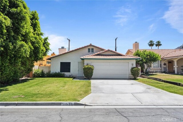 ranch-style house featuring a garage, stucco siding, a chimney, a front lawn, and driveway