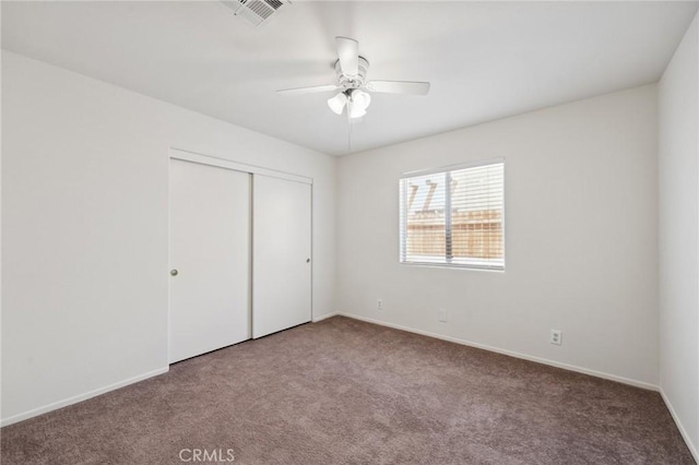 unfurnished bedroom with baseboards, carpet flooring, a closet, and visible vents