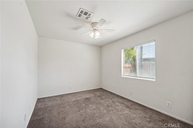 carpeted empty room featuring baseboards, a ceiling fan, and visible vents