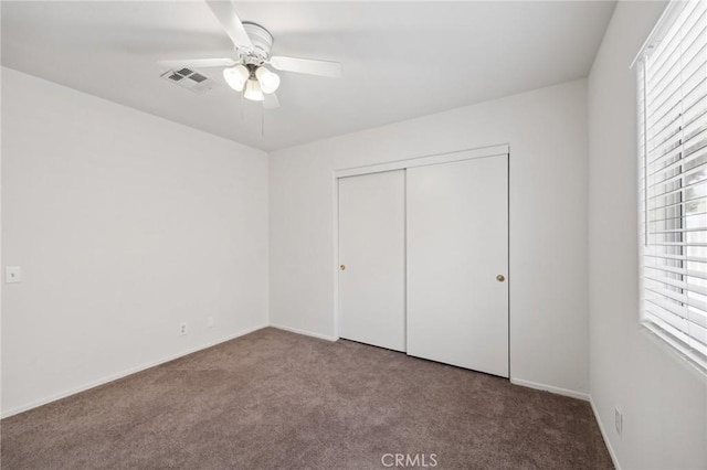 unfurnished bedroom with carpet, a closet, baseboards, and visible vents