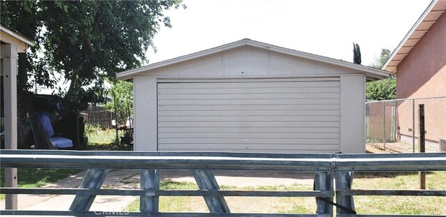 detached garage featuring fence