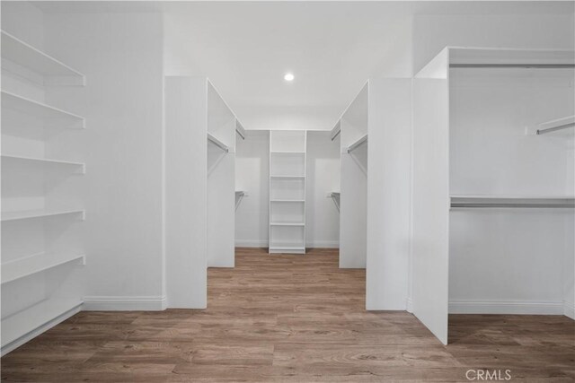 walk in closet with wood finished floors