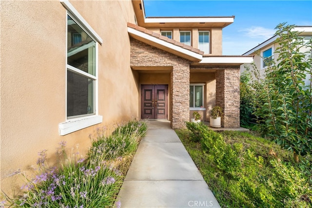 entrance to property with stone siding and stucco siding