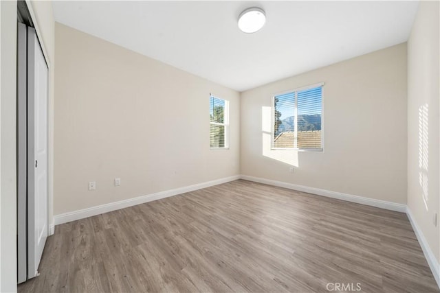 unfurnished bedroom featuring baseboards, a closet, and wood finished floors