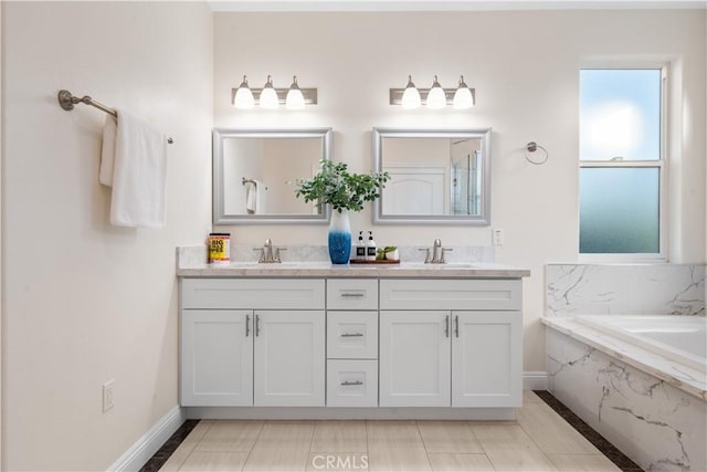 bathroom with baseboards, a bath, double vanity, and a sink