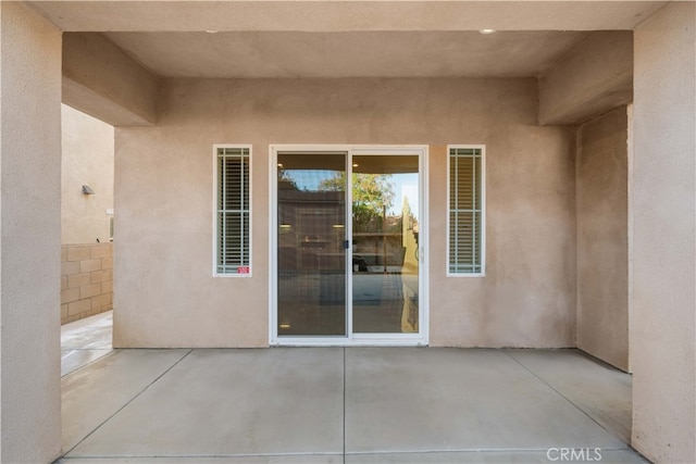 property entrance featuring a patio area and stucco siding