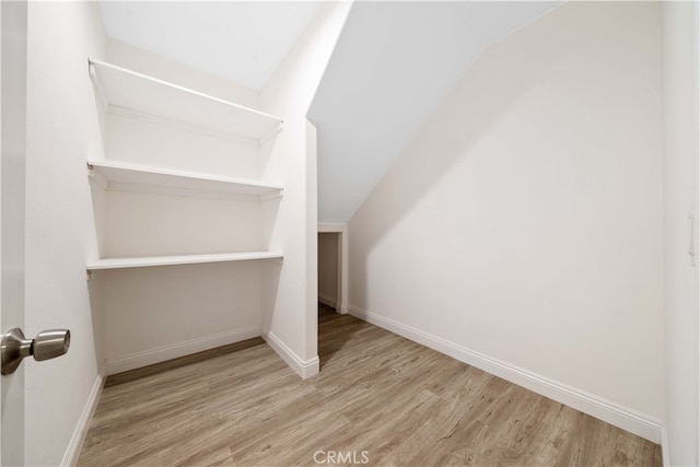 walk in closet with lofted ceiling and wood finished floors
