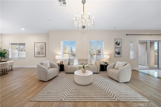 living room with a healthy amount of sunlight, visible vents, and wood finished floors