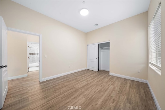 unfurnished bedroom with baseboards, light wood-type flooring, and visible vents