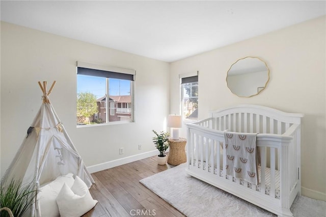2852 N Santa Fe Pl, Orange, CA 92865 - bedroom with baseboards, a crib, and wood finished floors