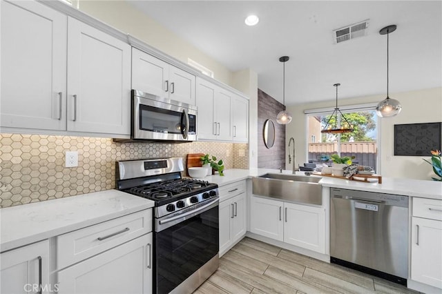 2852 N Santa Fe Pl, Orange, CA 92865 - kitchen with a sink, stainless steel appliances, visible vents, backsplash, and white cabinets