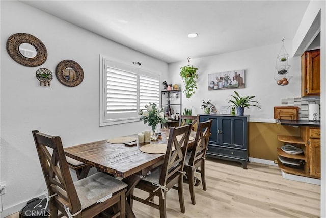 dining room featuring light wood finished floors and baseboards