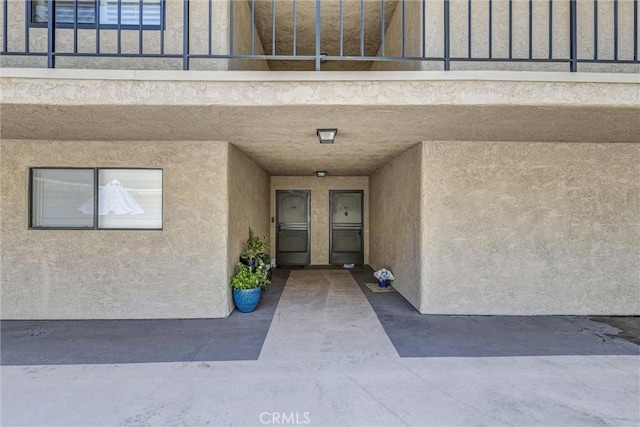 entrance to property with stucco siding