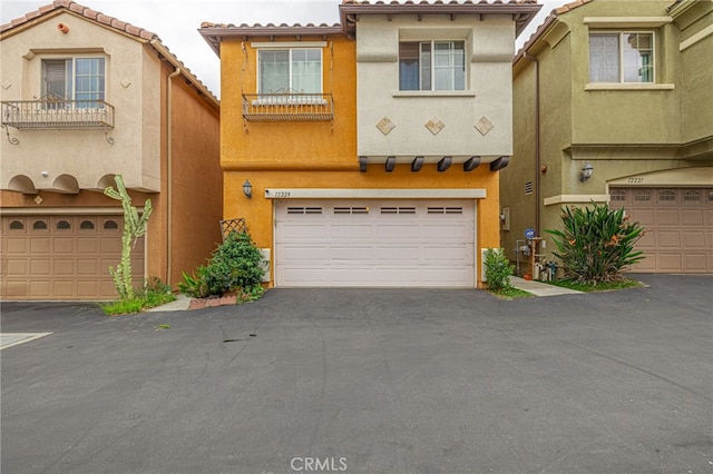 12229 Inspire Ln, Pacoima, CA 91331 - view of front of property featuring stucco siding, an attached garage, asphalt driveway, and a tile roof