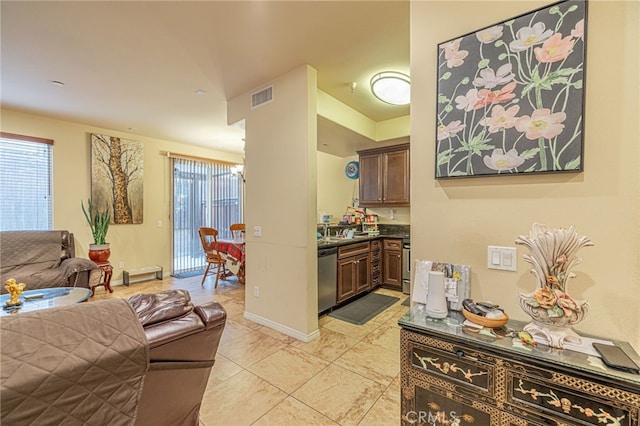 12229 Inspire Ln, Pacoima, CA 91331 - kitchen featuring stainless steel dishwasher, dark countertops, open floor plan, and baseboards