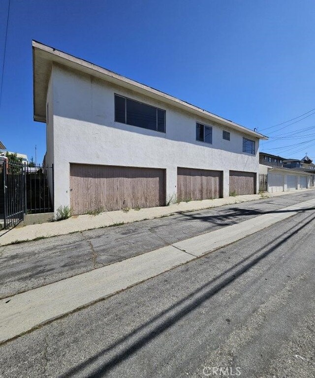 view of side of home with fence and stucco siding
