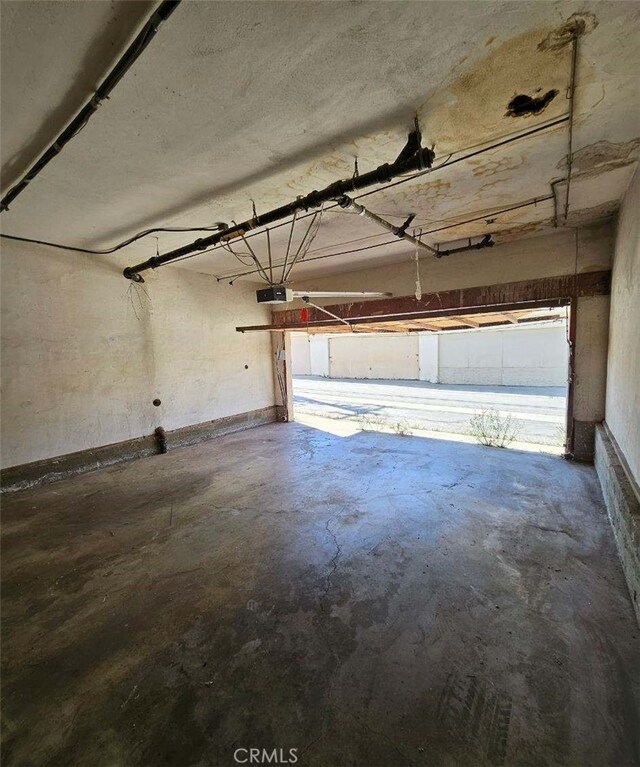 garage with baseboards and a garage door opener