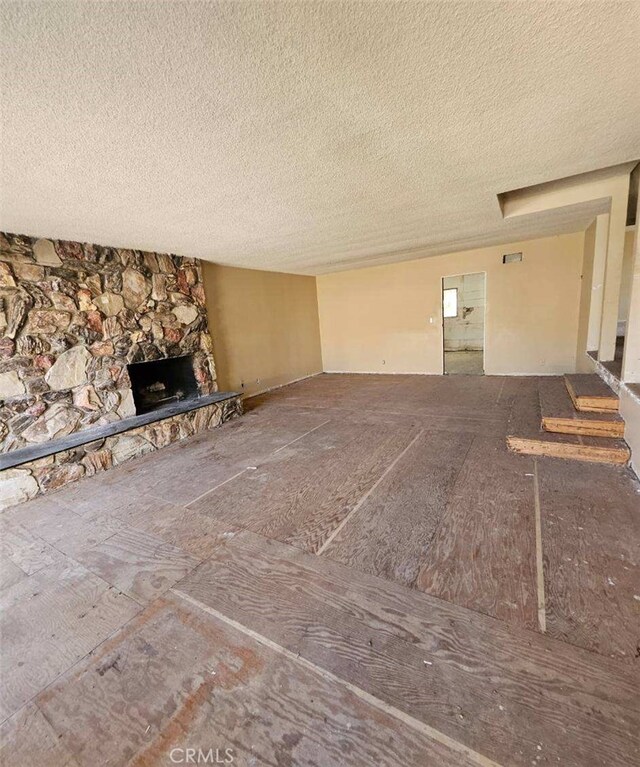 unfurnished living room featuring a fireplace and a textured ceiling