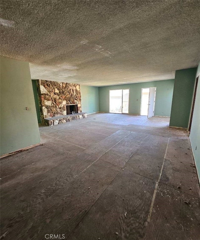 unfurnished living room featuring a textured ceiling and a fireplace