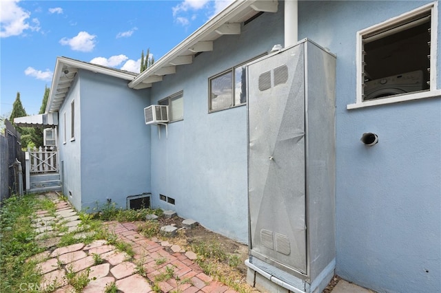 10546 Mcvine Ave, Sunland, CA 91040 - view of side of property with stucco siding, washer / dryer, fence, and a wall unit AC