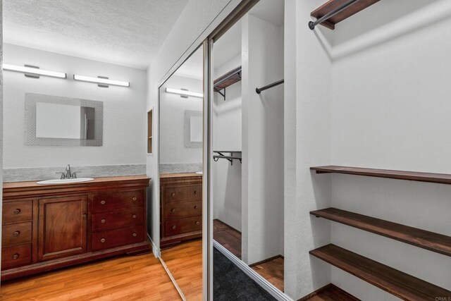 992 Lupine Hills Dr Unit 98, Vista, CA 92081 - bathroom featuring a textured ceiling, wood finished floors, and vanity