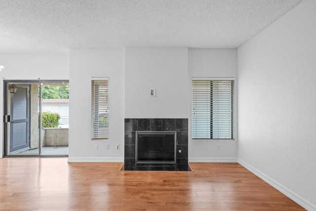 992 Lupine Hills Dr Unit 98, Vista, CA 92081 - unfurnished living room with a textured ceiling, a tile fireplace, baseboards, and wood finished floors