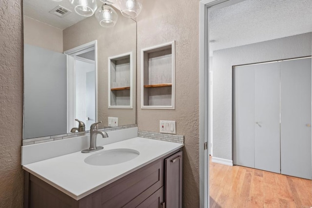 992 Lupine Hills Dr Unit 98, Vista, CA 92081 - bathroom featuring wood finished floors, visible vents, a textured wall, a chandelier, and vanity