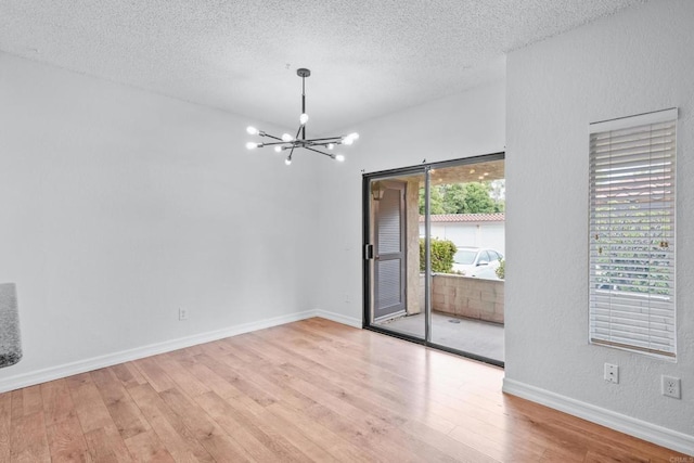 992 Lupine Hills Dr Unit 98, Vista, CA 92081 - unfurnished room with baseboards, a chandelier, a textured ceiling, and wood finished floors