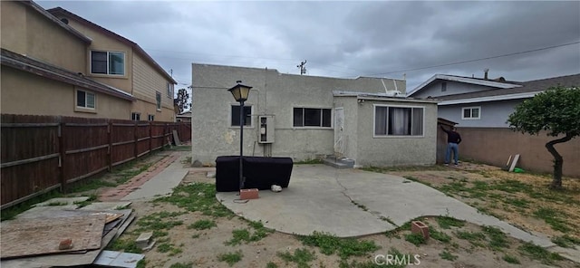back of property featuring a patio, stucco siding, and a fenced backyard