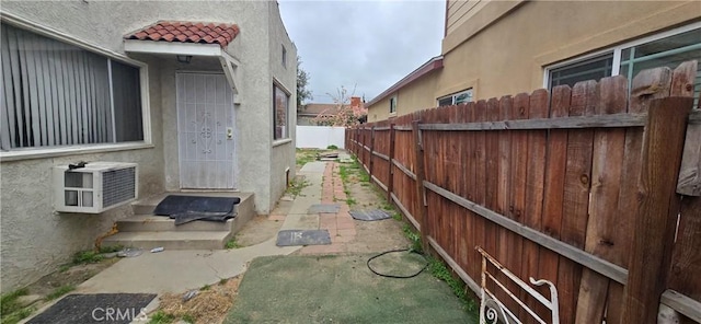 view of side of property featuring stucco siding, a tile roof, and fence
