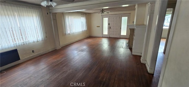interior space with baseboards, a ceiling fan, a healthy amount of sunlight, and wood finished floors